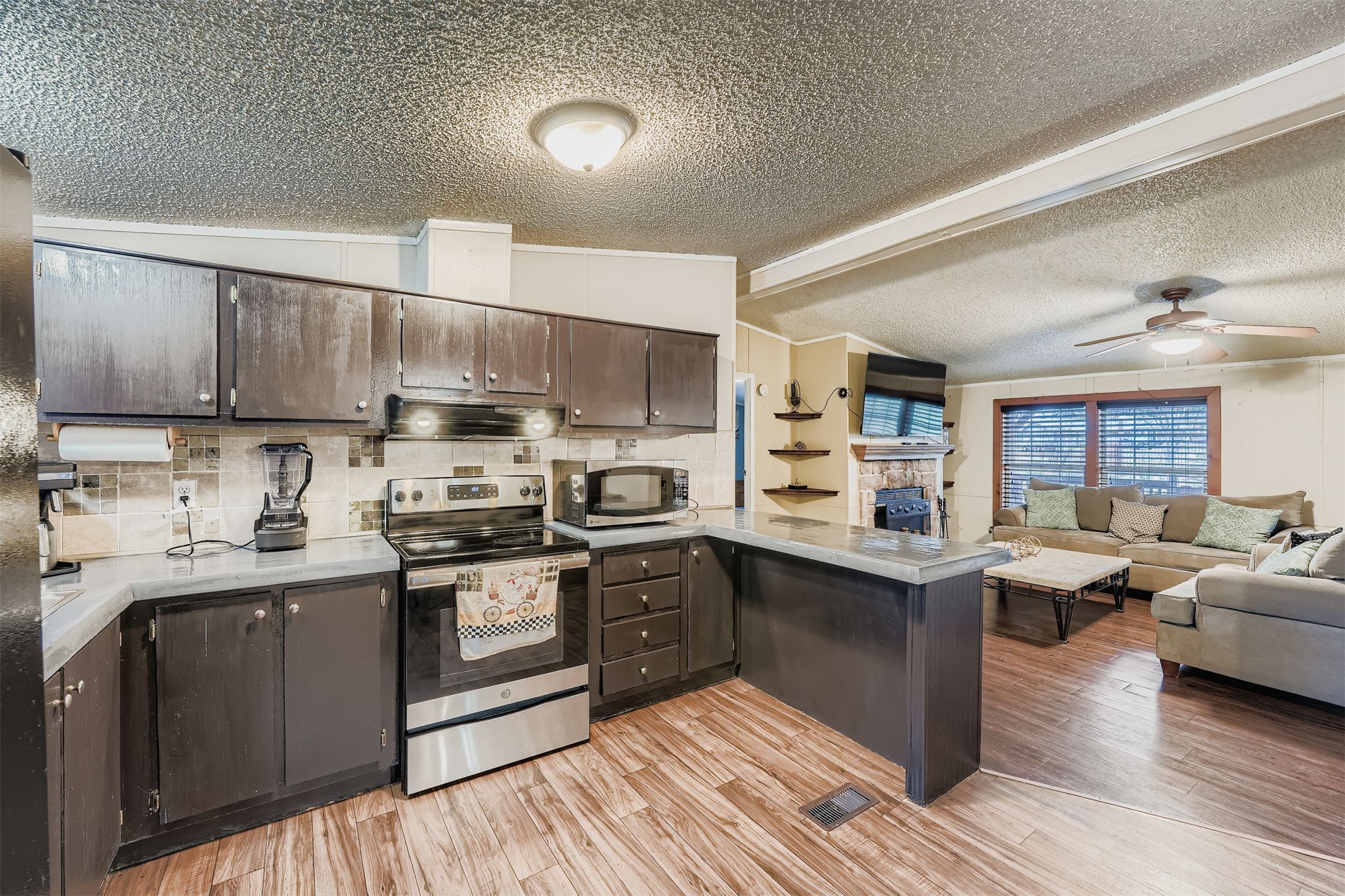 145 Alyssa Loop Bastrop, TX 78602 - Photo 14 of 40 a kitchen with stainless steel appliances granite countertop a sink dishwasher stove top oven and cabinets with wooden floor