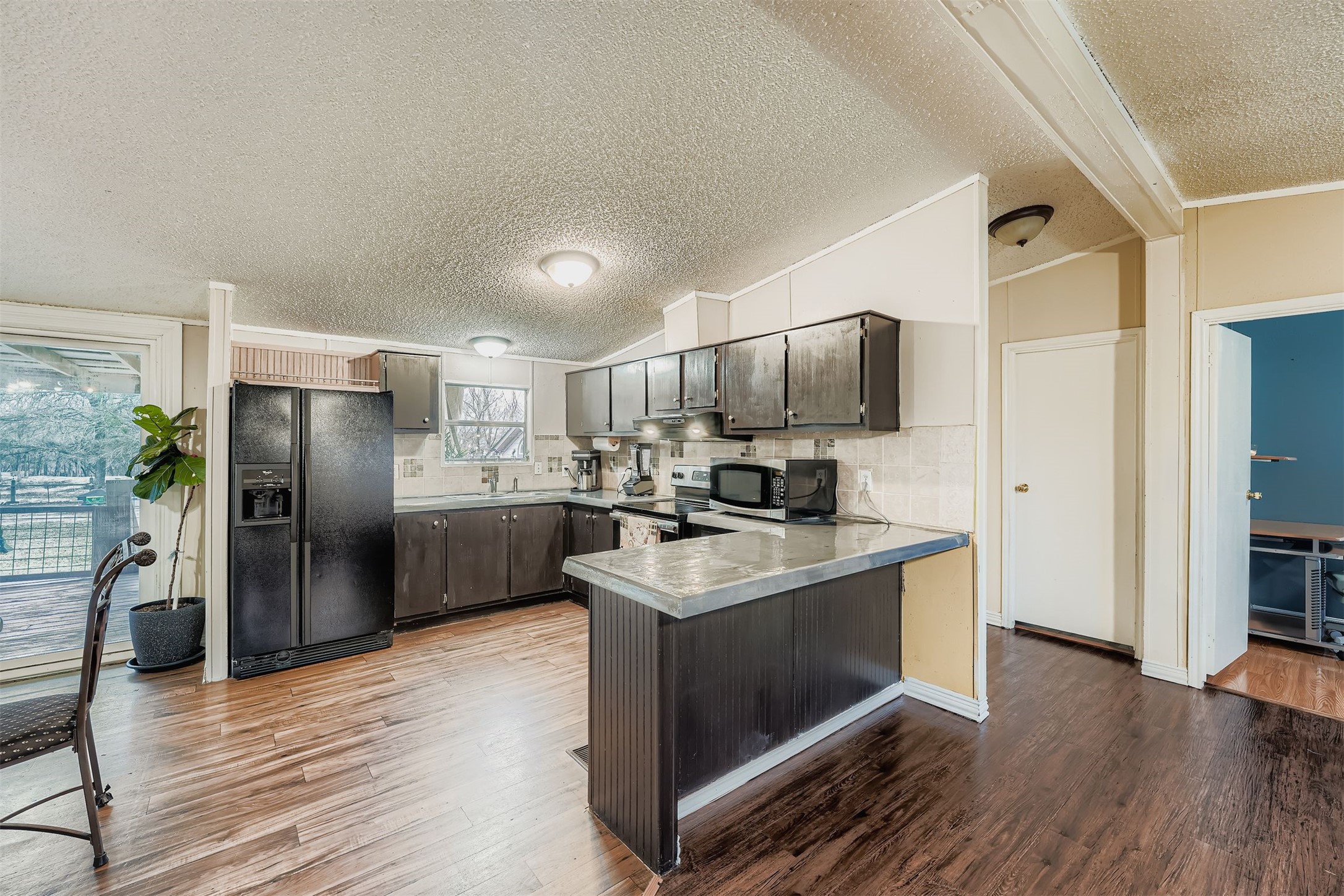 145 Alyssa Loop Bastrop, TX 78602 - Photo 16 of 40 a kitchen with kitchen island stainless steel appliances a sink cabinets and refrigerator