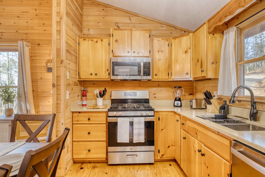 180 Green Ridge Road Blue Ridge, GA 30513 - Photo 41 of 83 a kitchen with stainless steel appliances granite countertop a stove a sink and a microwave