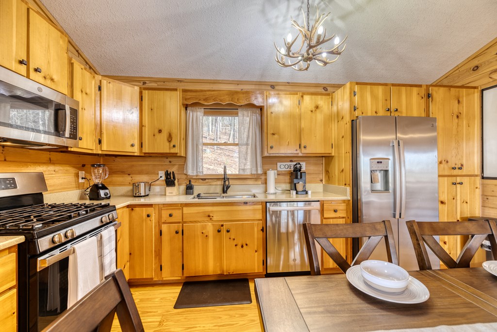 180 Green Ridge Road Blue Ridge, GA 30513 - Photo 42 of 83 a kitchen with stainless steel appliances a sink a stove a refrigerator cabinets and dining table