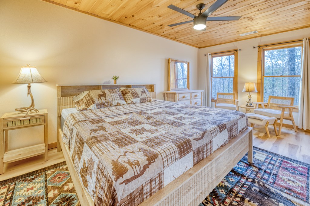 180 Green Ridge Road Blue Ridge, GA 30513 - Photo 9 of 83 a spacious bedroom with a bed a chandelier and next to a window