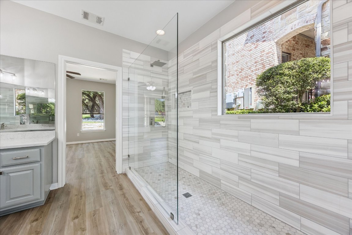 308 Calistoga Court Austin, TX 78732 - Photo 28 of 40 a bathroom with a glass shower door and a bathtub