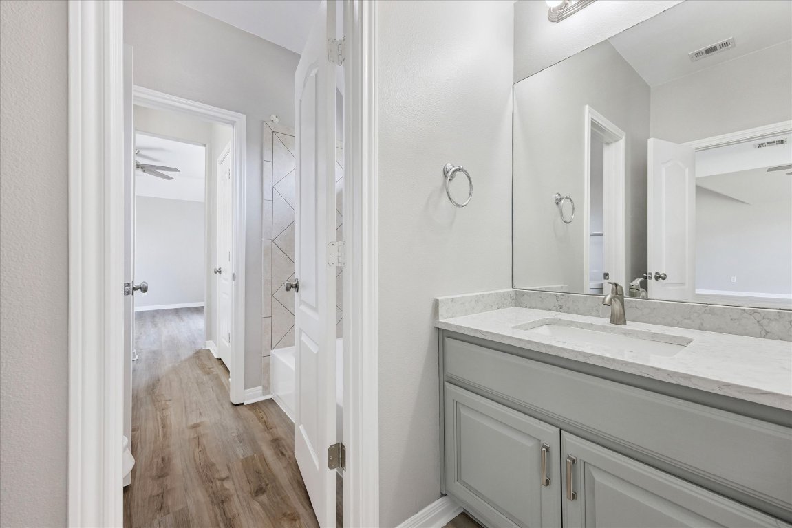 308 Calistoga Court Austin, TX 78732 - Photo 32 of 40 a en suite bathroom with a granite countertop sink