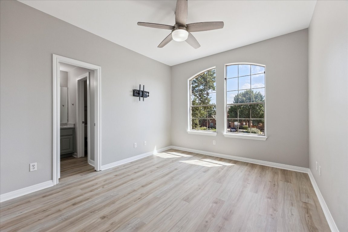 308 Calistoga Court Austin, TX 78732 - Photo 35 of 40 an empty room with wooden floor chandelier fan and windows