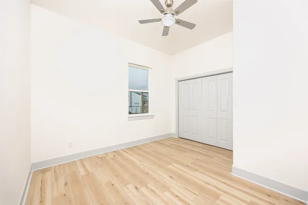 a view of a room with a window and wooden floor