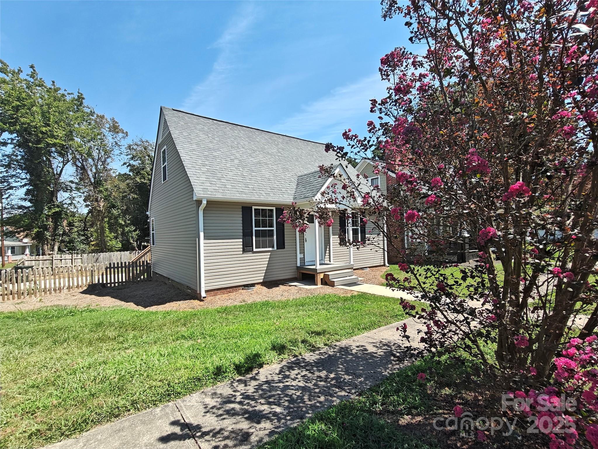 406 4th Street Spencer, NC 28159 - Photo 1 of 16 a front view of a house with a yard and garage