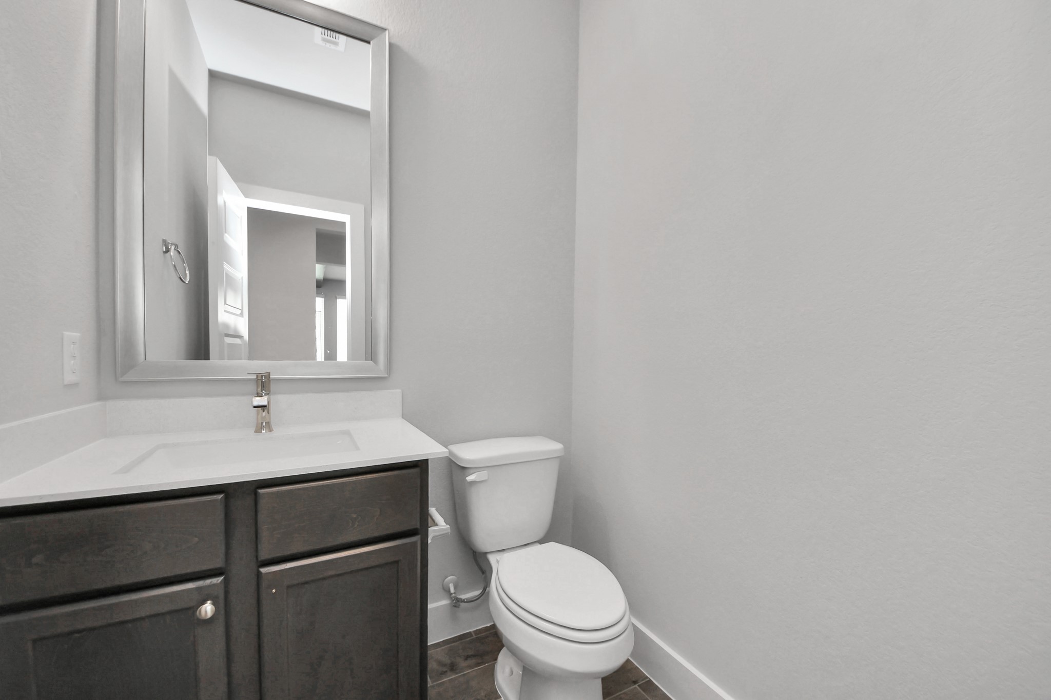 3110 Native Spg Drive Spring, TX 77373 - Photo 7 of 34 Sophisticated half bathroom adorned with contemporary finishes. The elegant 5-panel door welcomes you to a space where style meets functionality. Notice the sleek hardware accents that add a touch of modern charm. The vanity boasts light-colored countertops, beautifully complemented by a tasteful vanity light, creating a well-lit and inviting atmosphere. Sample photo of completed home with similar floor plan. Actual colors and selections may vary.
