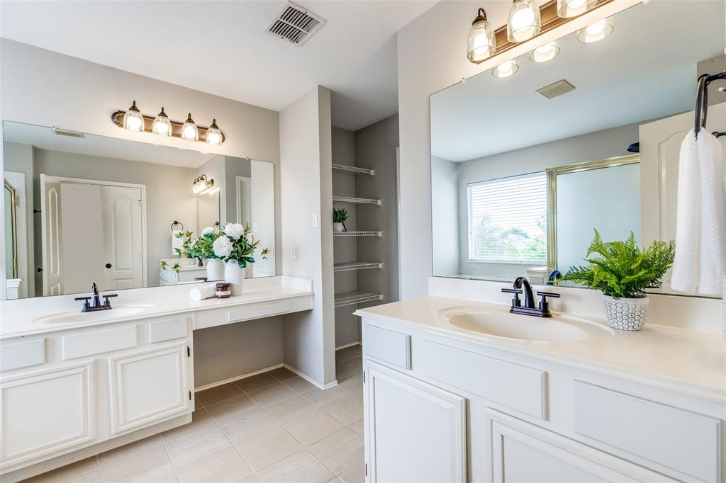 1445 Berkley Road Allen, TX 75002 - Photo 17 of 30 Separate vanities are practical and convenient. The one to the right is higher than the sink and vanity space on the left. Open shelves provide great linen storage and there is a private water closet.