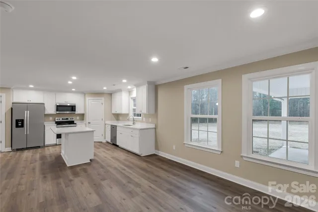 a kitchen with a wooden floor and window