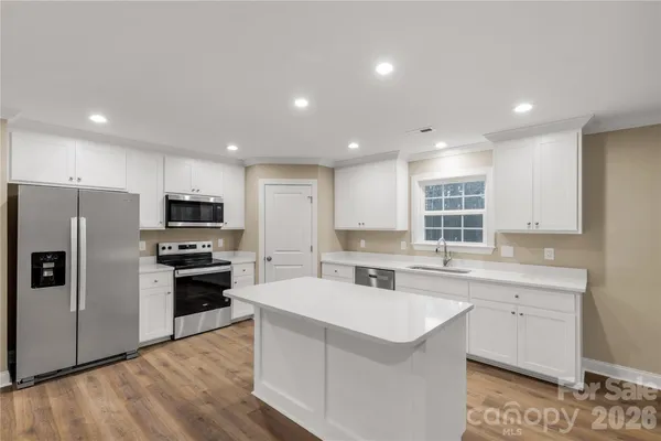 a kitchen with stainless steel appliances a sink stove and refrigerator