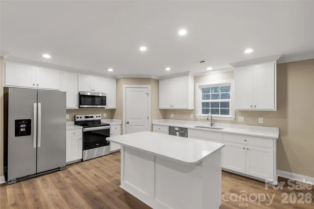 a kitchen with stainless steel appliances a sink stove and refrigerator