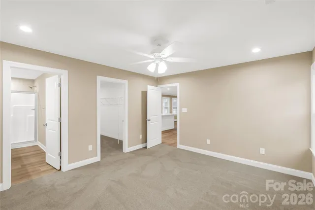 an empty room with closet and a ceiling fan