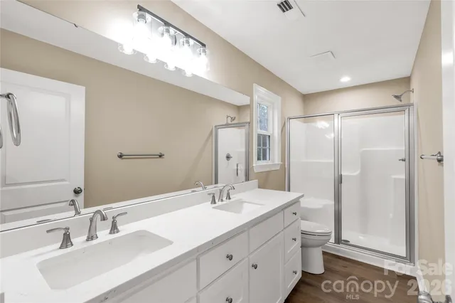 a bathroom with a double vanity sink mirror and toilet