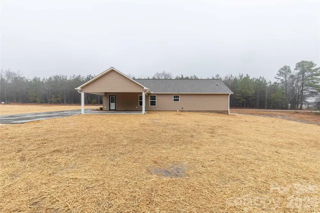 a front view of house with yard and trees in the background
