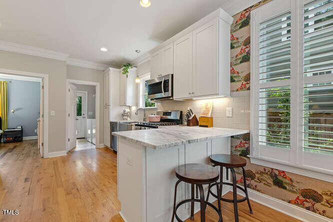 3012 Shenandoah Avenue Durham, NC 27704 - Photo 19 of 50 a kitchen with stainless steel appliances a stove a sink a refrigerator and cabinets