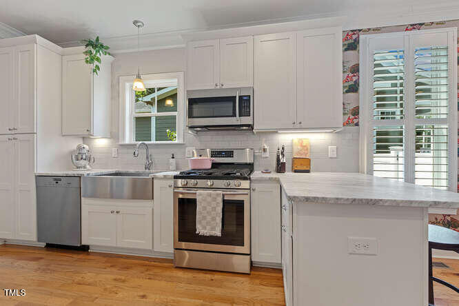 3012 Shenandoah Avenue Durham, NC 27704 - Photo 21 of 50 a kitchen with stainless steel appliances granite countertop a stove a sink and a microwave
