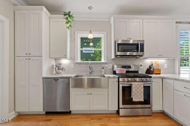 3012 Shenandoah Avenue Durham, NC 27704 - Photo 22 of 50 a kitchen with stainless steel appliances a stove a sink and a microwave