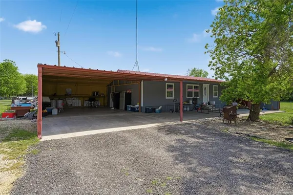 a view of a house with a patio and a yard