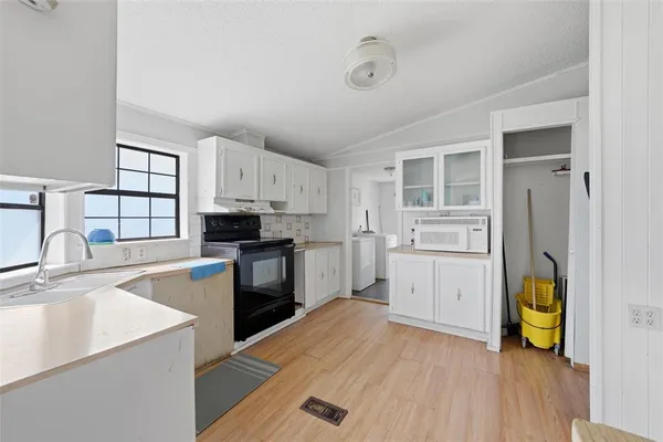 a kitchen with a refrigerator and a stove top oven