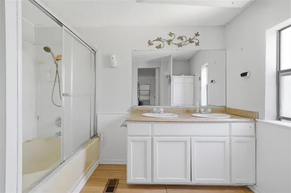 a bathroom with a granite countertop sink a mirror a vanity and a bathtub