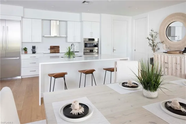 a kitchen with appliances a table and chairs