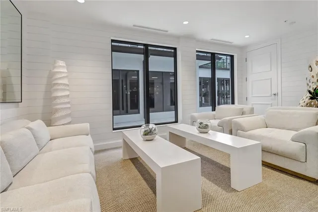 a large white kitchen with stainless steel appliances granite countertop a sink and a microwave
