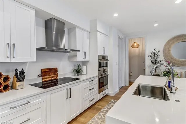 a kitchen with stainless steel appliances granite countertop a sink a stove and cabinets