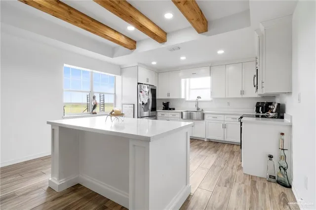 a kitchen with white cabinets and sink