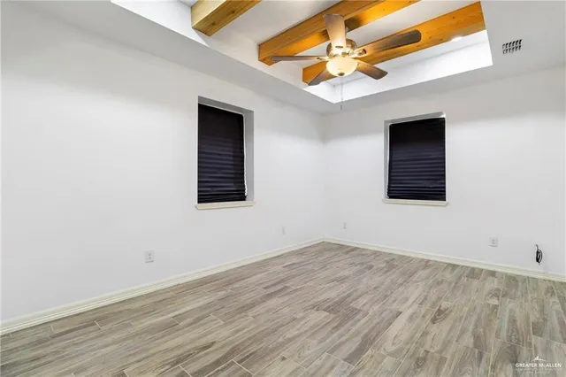 an empty room with a window and a ceiling fan
