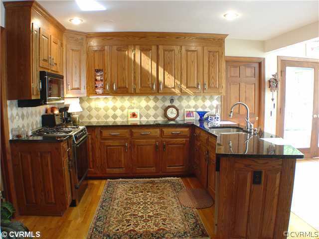 13901 Elmstead Road Midlothian, VA 23113 - Photo 5 of 12 a kitchen with a sink stove and cabinets