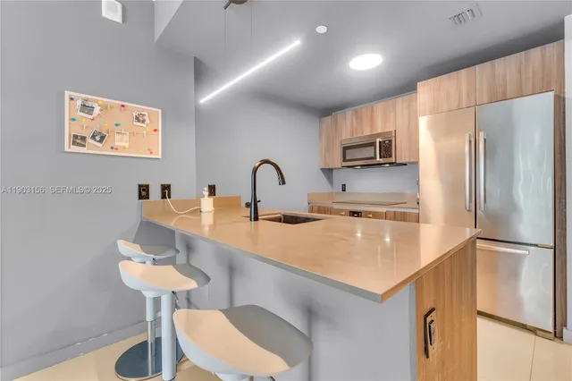 a kitchen with stainless steel appliances a refrigerator and a sink