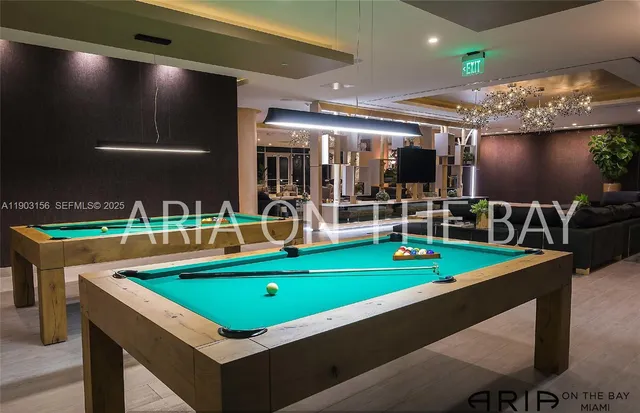 a room with pool table and chairs