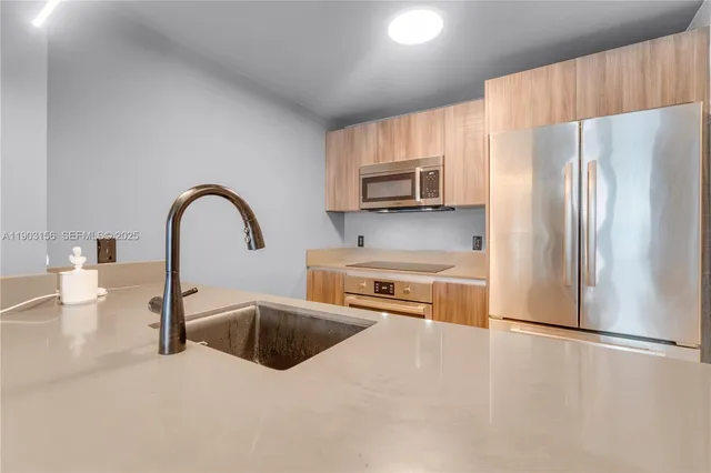 a kitchen with stainless steel appliances a refrigerator sink and cabinets