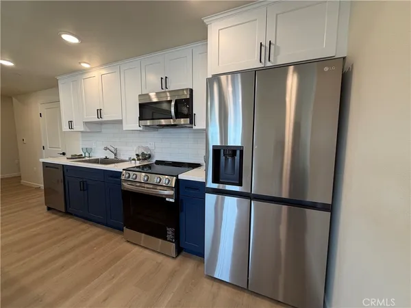 a kitchen with stainless steel appliances granite countertop a refrigerator and a stove top oven
