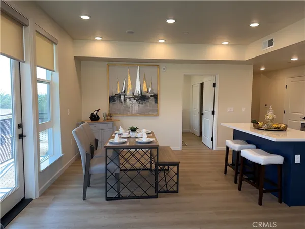 a view of a a dining room with furniture window and wooden floor