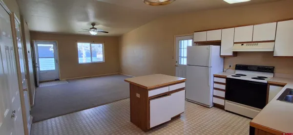 a kitchen with kitchen island granite countertop a stove and a refrigerator
