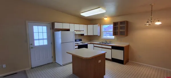 a kitchen with kitchen island a counter top space a sink stainless steel appliances and cabinets