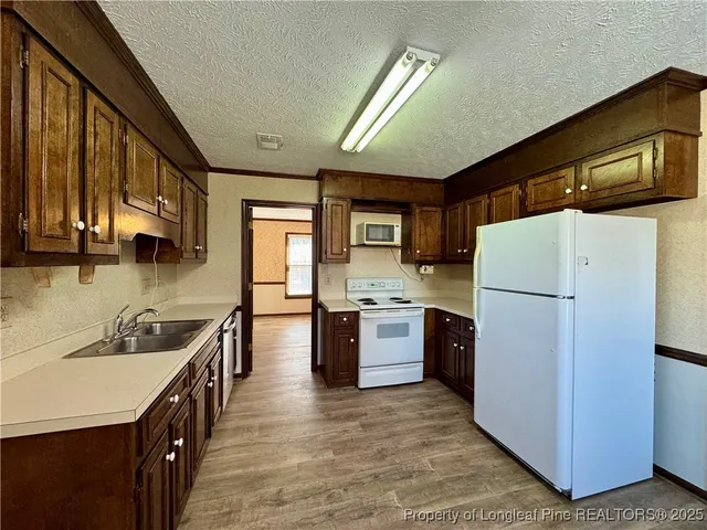 a kitchen with a refrigerator a sink dishwasher stove and oven