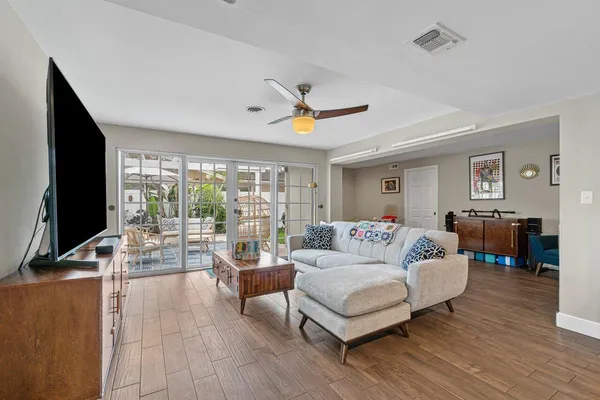 a living room with furniture flat screen tv and a large window