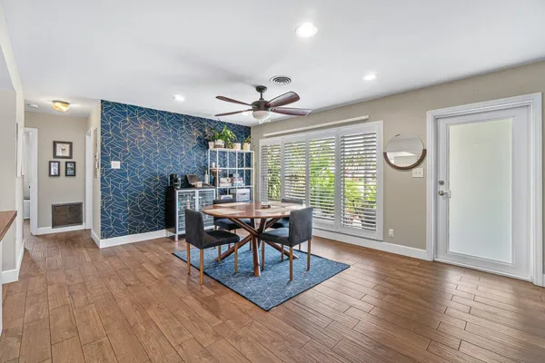 a dining room with furniture window entryway and wooden floor