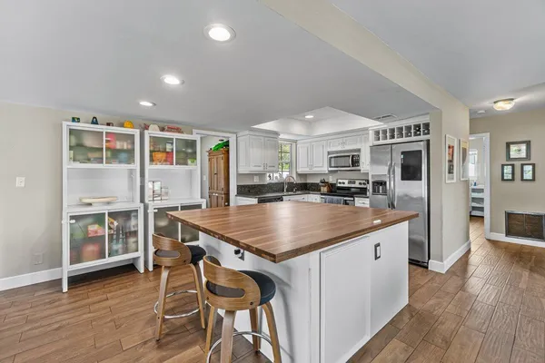 a kitchen with stainless steel appliances granite countertop a sink a stove and a refrigerator