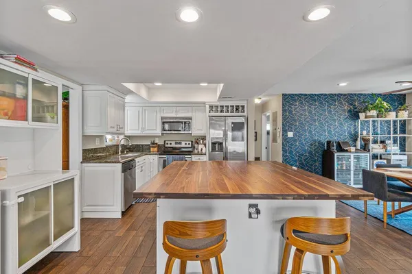 a kitchen with stainless steel appliances granite countertop a kitchen island a stove a table and chairs in it
