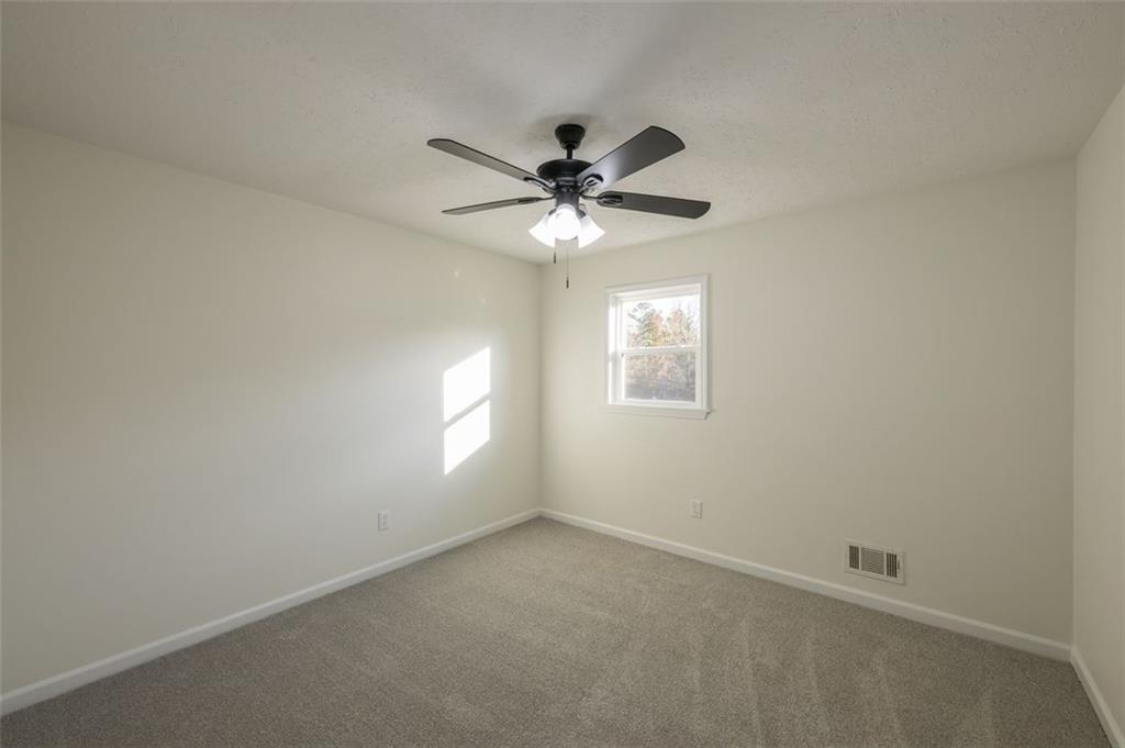 5081 Hubert Drive Powder Springs, GA 30127 - Photo 31 of 32 an empty room with windows and chandelier fan
