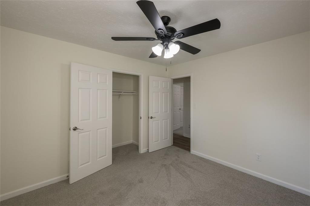 5081 Hubert Drive Powder Springs, GA 30127 - Photo 32 of 32 an empty room with closet and a chandelier fan