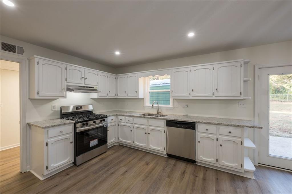 5081 Hubert Drive Powder Springs, GA 30127 - Photo 10 of 32 a kitchen with granite countertop white cabinets and stainless steel appliances