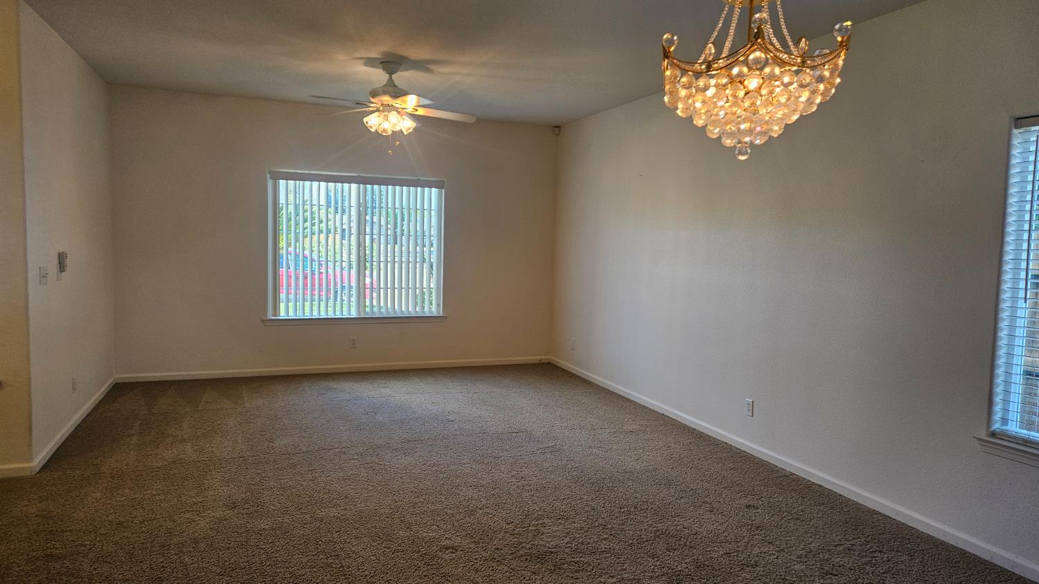 580 West Sunset Street Kingsburg, CA 93631 - Photo 4 of 12 an empty room with a chandelier fan and window