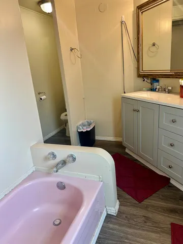 a bathroom with a tub sink and mirror