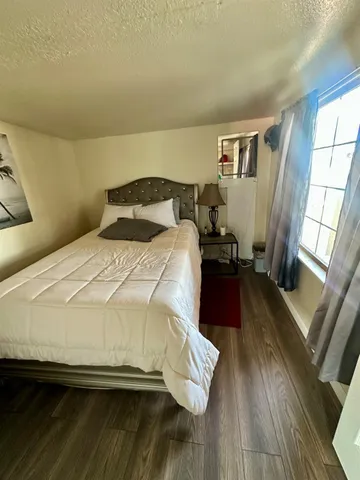 a bedroom with a bed and wooden floor