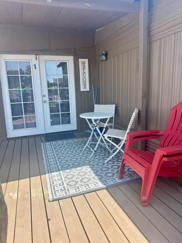 a view of a workspace with wooden floor and furniture