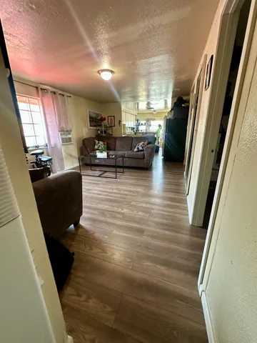 a living room with furniture floor to ceiling window and a wooden floor